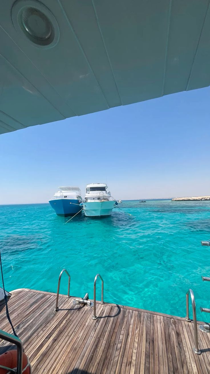 Boats anchored in turquoise water, seen from the boat deck