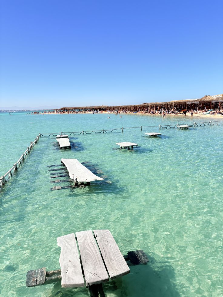 Wooden tables in the shallow turquoise water at Orange Bay