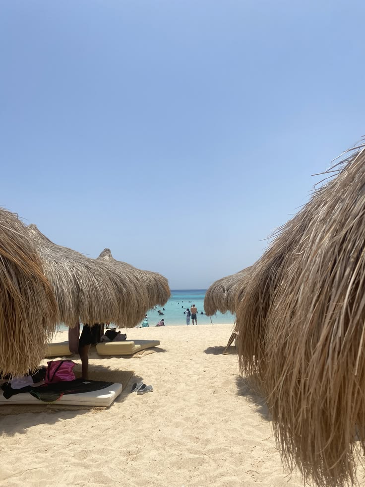 Straw umbrellas and sun beds on the white-sand beach