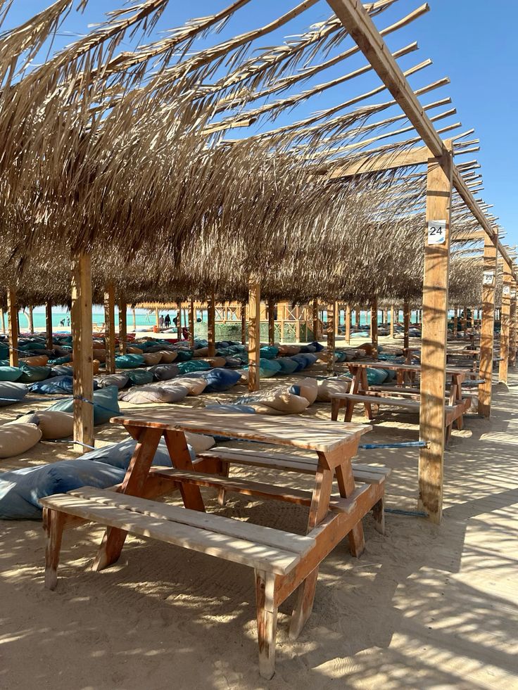 Wooden picnic tables under the straw shades