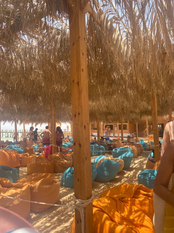 Guests relaxing on bean bags under the straw shades