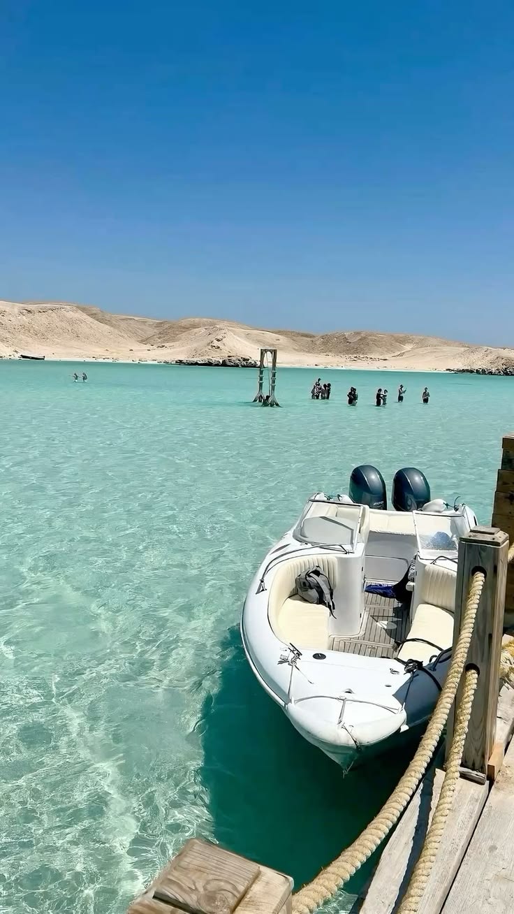 Speedboat moored at a wooden jetty in shallow turquoise water